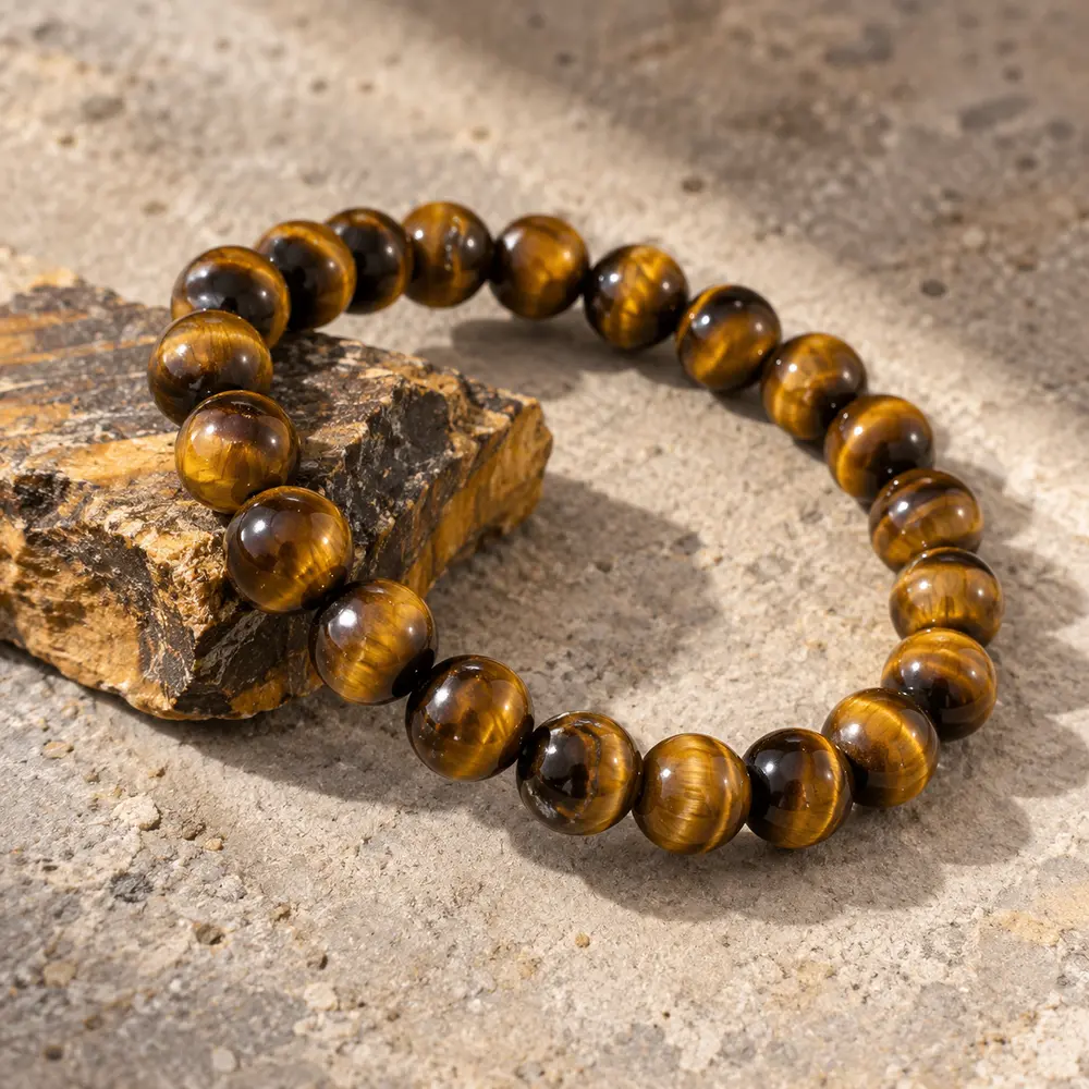 Golden tiger's eye bracelet beside a rough tiger's eye stone