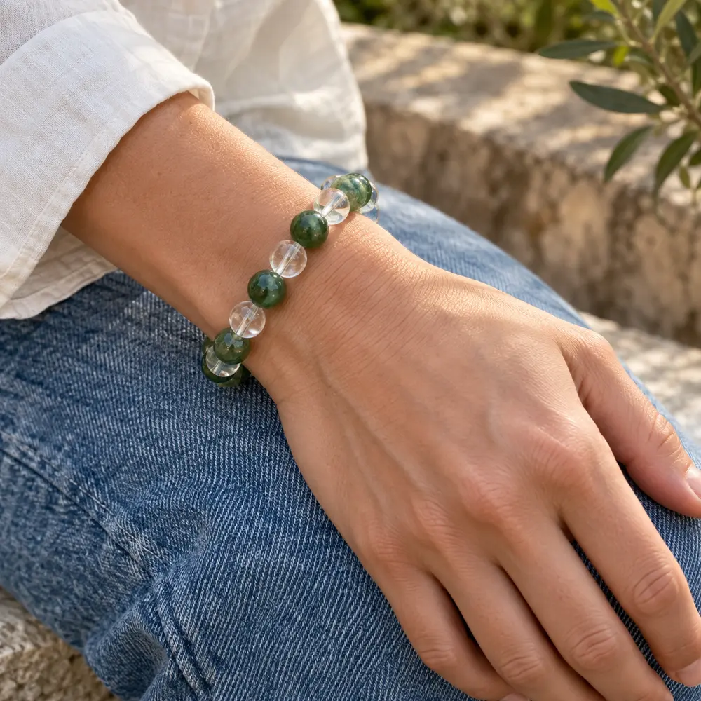 Green, blue, and clear crystal bead bracelet worn with a white sleeve
