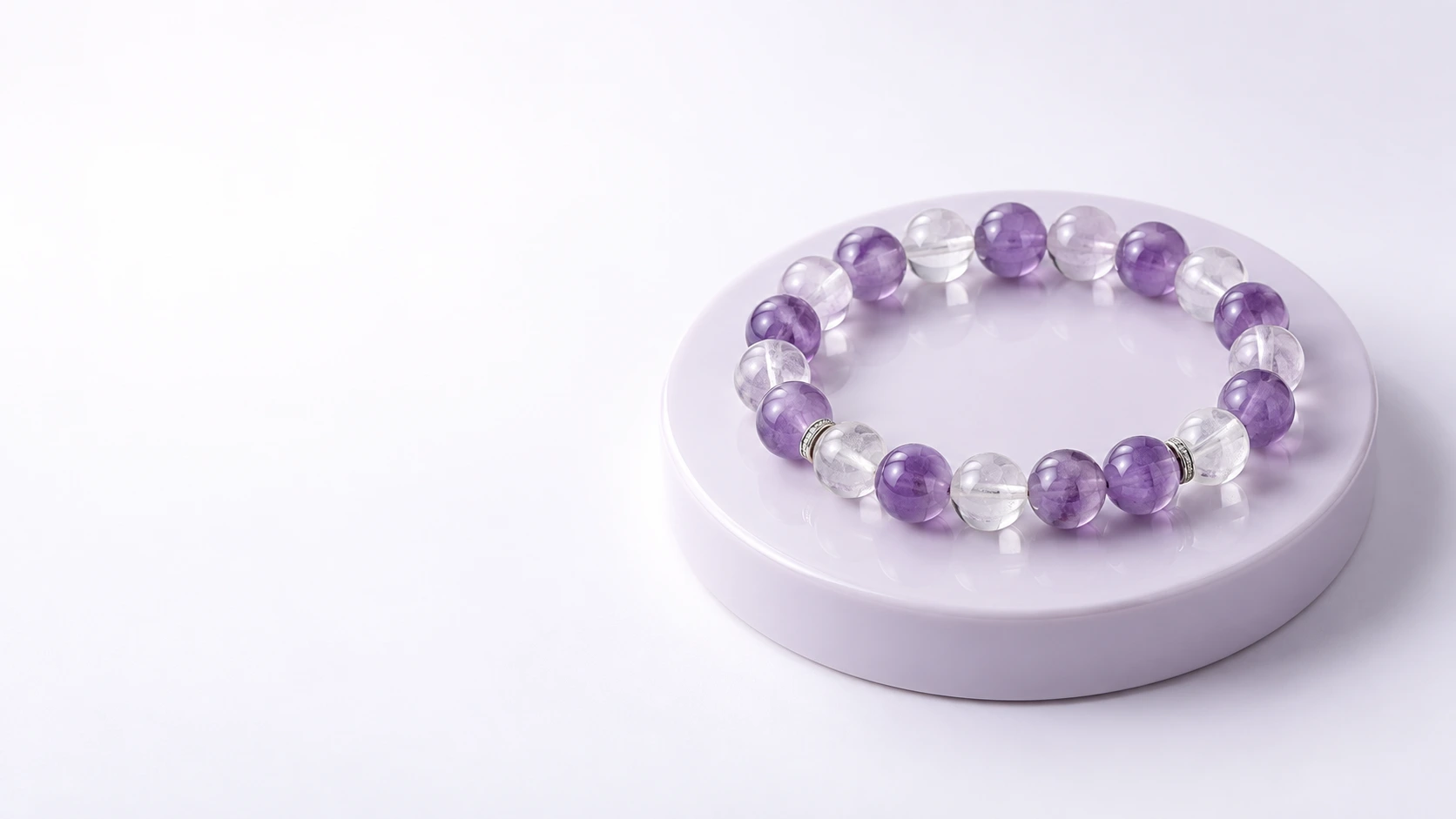 Lavender amethyst and clear quartz bracelet on a pale lilac ceramic display