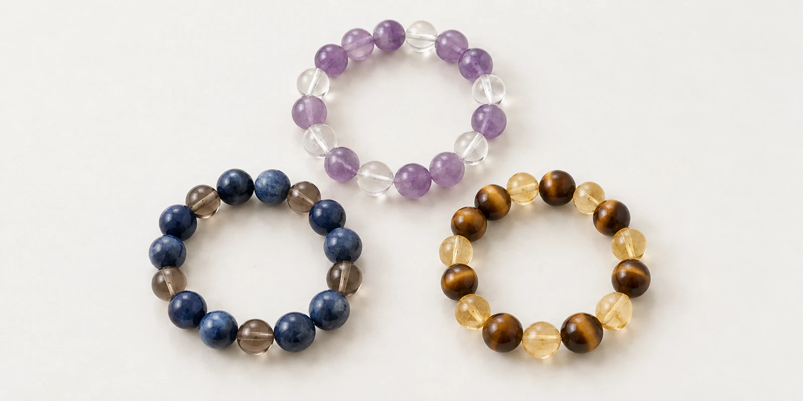 Three crystal bracelets in lavender, blue-gray and warm golden palettes